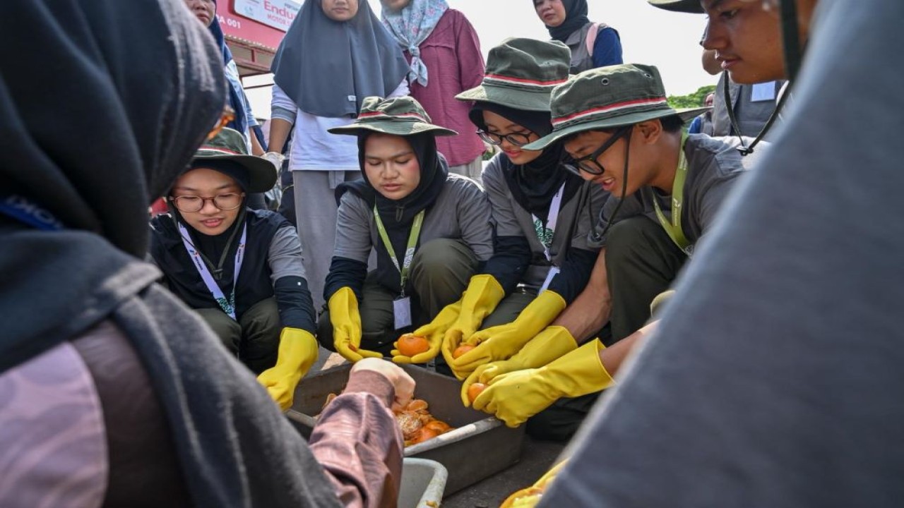 Para peserta program Greenbus Pertamina 2026 Season 2 sedang melalukan pemilahan sisa makanan untuk diolah menjadi pakan magot di Kampung Hijau Cemara, Jakarta, Kamis, (2/7/2026).